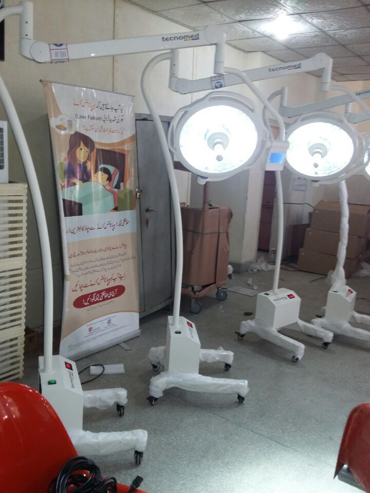 Multiple LEDD700/500 ceiling operating lights and LEDL500S mobile surgical lights delivered to a Pakistani military hospital, with original packaging and Urdu-language liver failure awareness poster