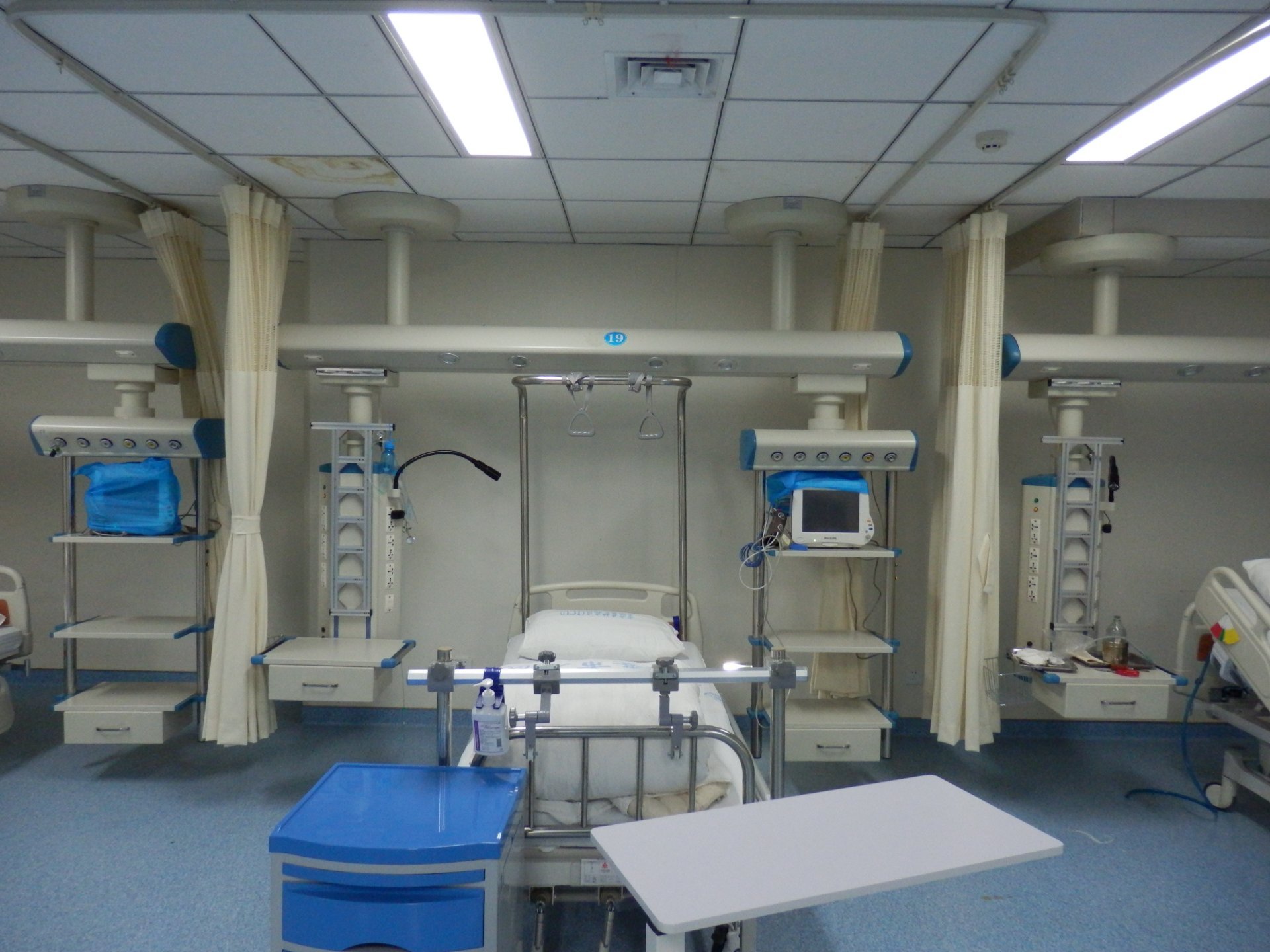 Close-up detail of the QF-JX-300 ICU bridge at Lu'an People's Hospital showing the dry/wet zone design, equipment shelves and gas terminal outlets at the head of bed