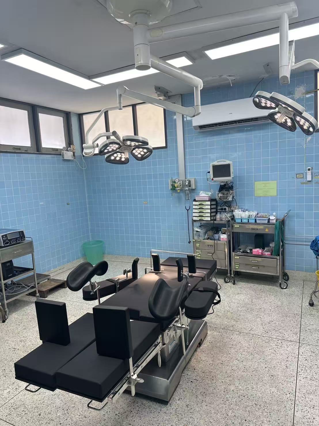 TDY-Y-2 electro-hydraulic multifunctional operating table installed in the operating room of Saraphi Hospital in Chiang Mai, Thailand, surrounded by ceiling-mounted surgical LED lights and an anesthesia cart