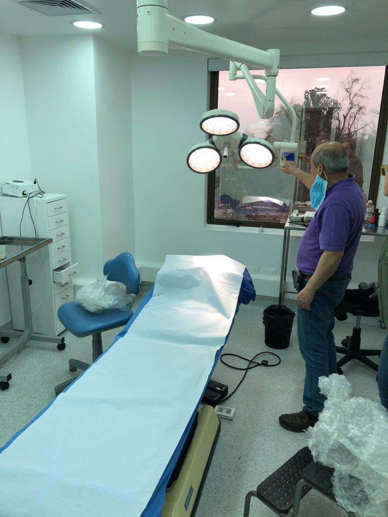 Hospital operating-room manager inspecting the LEDD740/740 surgical light during on-site acceptance in Chile, verifying beam quality and head movement
