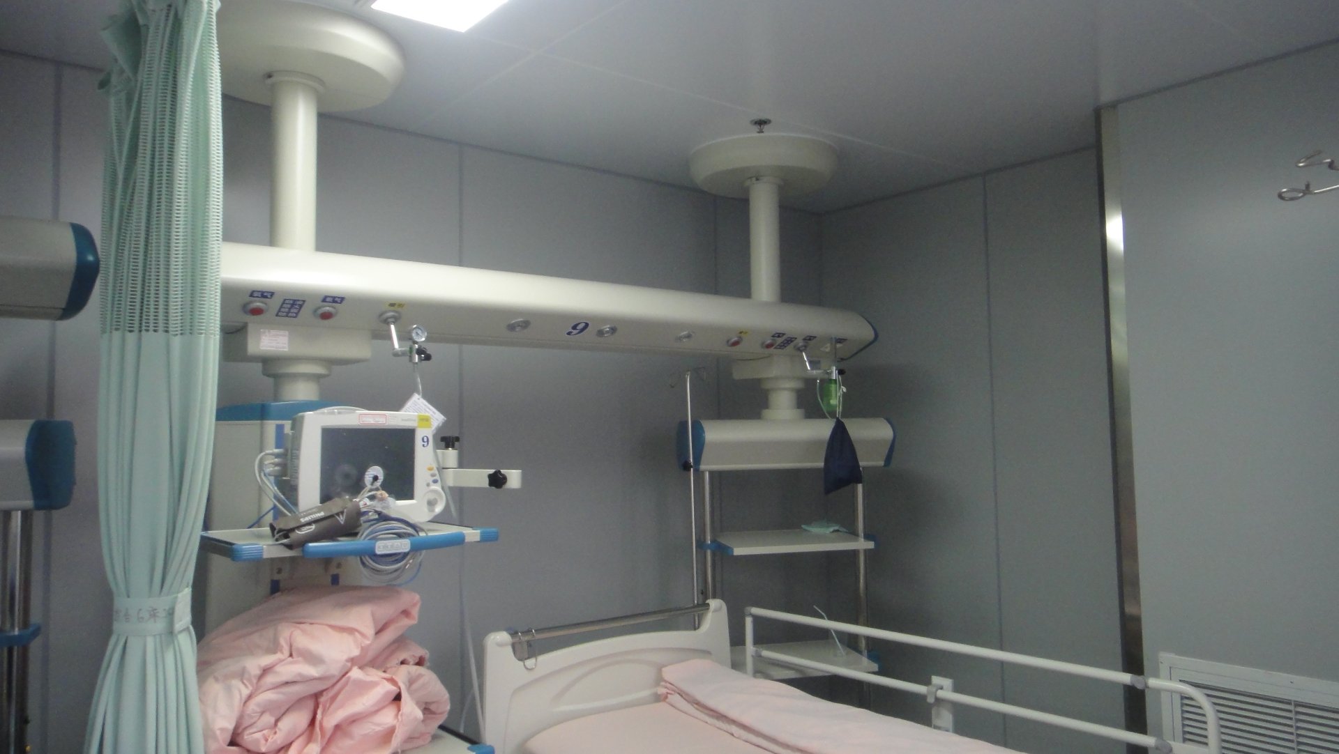 Ceiling-Mounted ICU Bridge Commissioned at Shanghai Jing'an District Central Hospital Newly commissioned ceiling-mounted ICU bridge spanning the patient bed inside the intensive care unit at Shanghai Jing'an District Central Hospital, integrating oxygen, suction, power and nurse-call connections above the head of bed