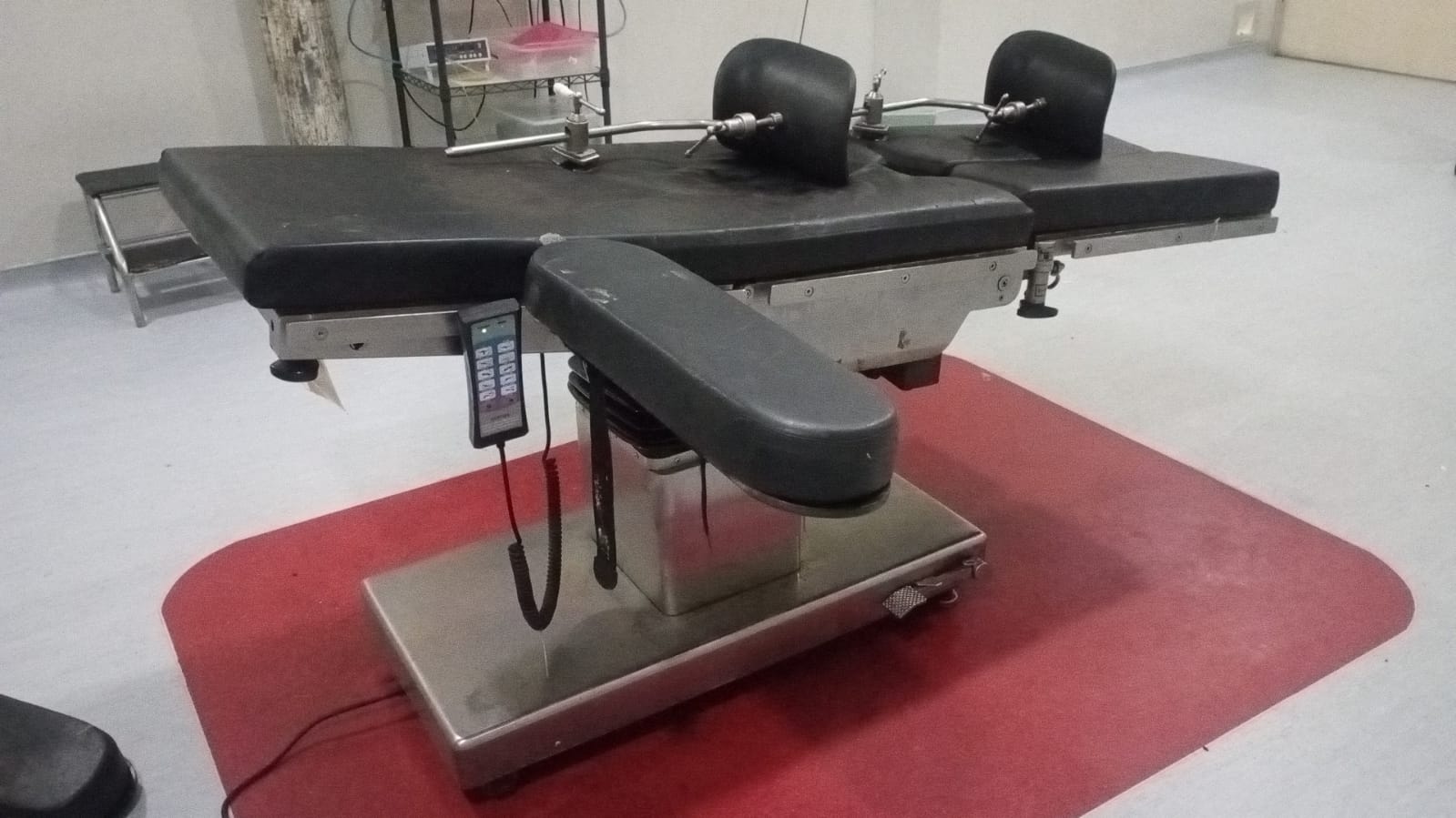 Close-up of the wired handheld remote controller and hydraulic column of the TDY-1 Electric Operating Table, the same unit in active eight-year service at the Indonesian hospital in the case study.