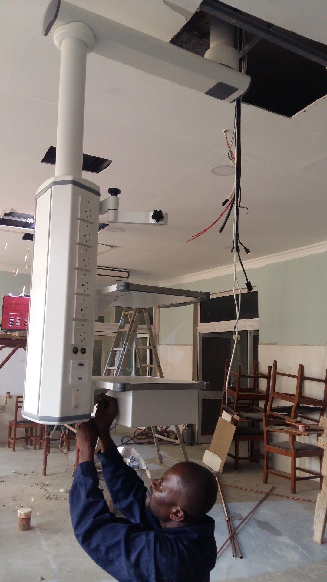 Modular medical pendant system installed at RUMA Fertility & Specialist Hospital, Ghana, showing column and shelf configuration