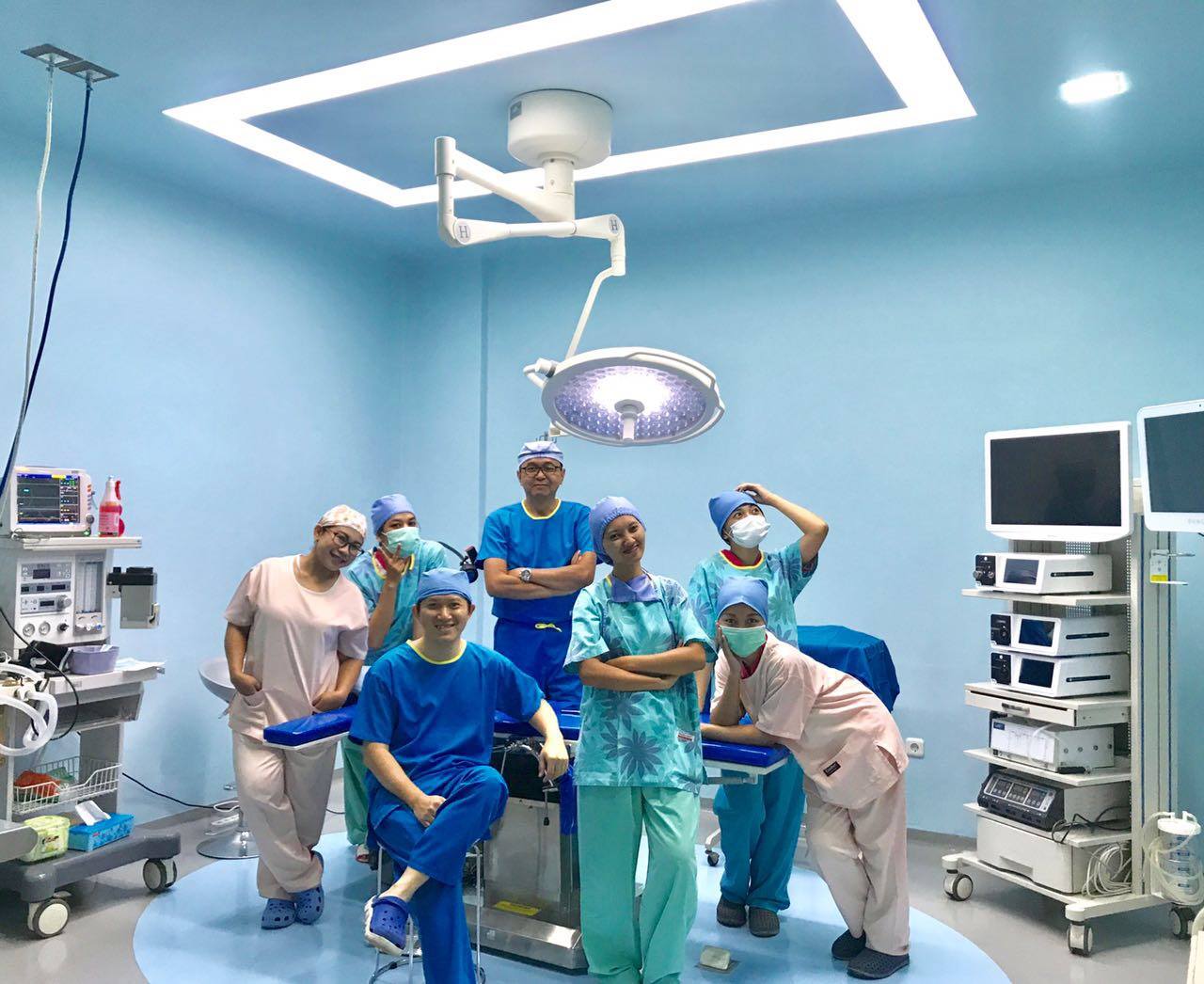 Red Sun Medi Zone Limited LEDD700 single-head ceiling surgical light installed at VetSurge Pte Ltd advanced veterinary clinic in Singapore, with the surgical team posing under the LEDD260 ceiling examination light