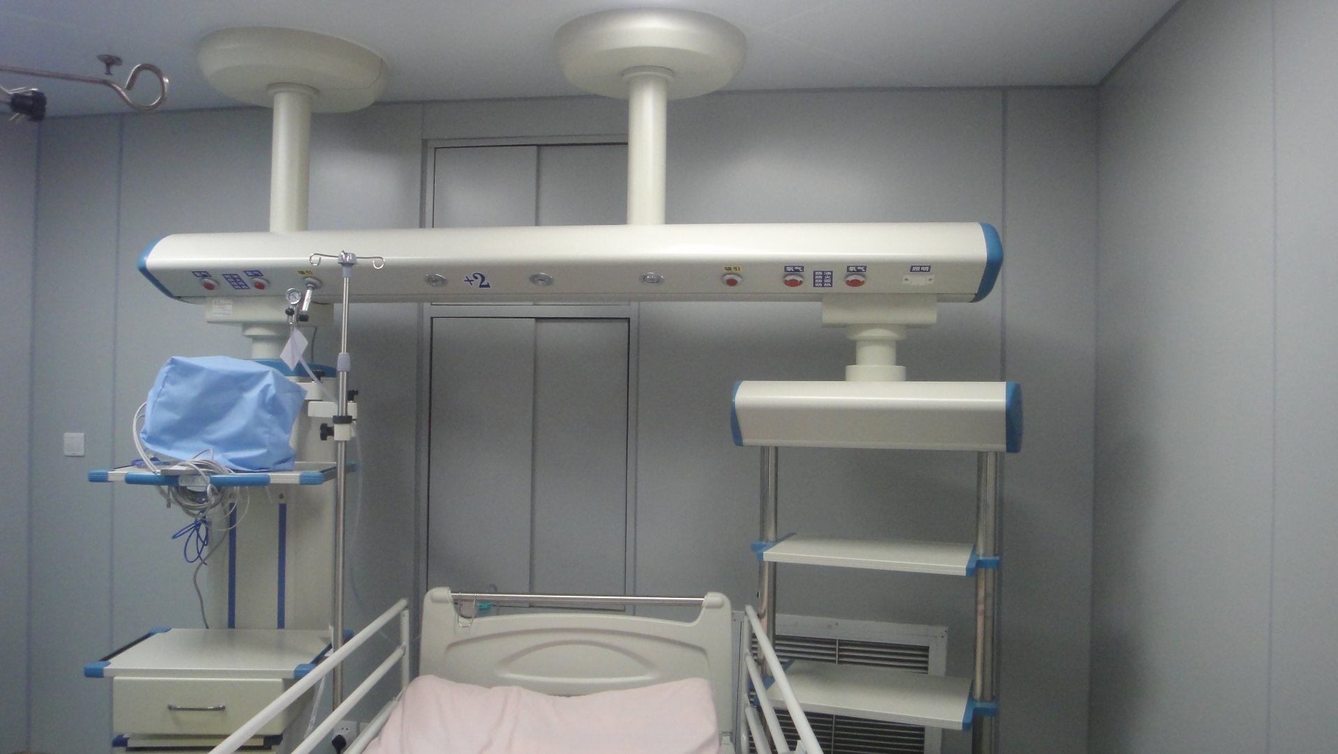 ICU Ward with Ceiling-Mounted ICU Bridges and Privacy Curtains ICU ward at Shanghai Jing'an District Central Hospital showing ceiling-mounted ICU bridges installed along a row of beds separated by privacy curtains, with patient monitors mounted overhead